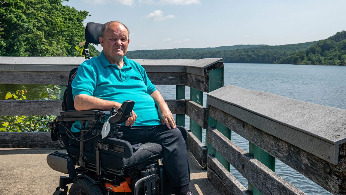 Man with motorized wheelchair sitting on Lake Scranton fishing pier